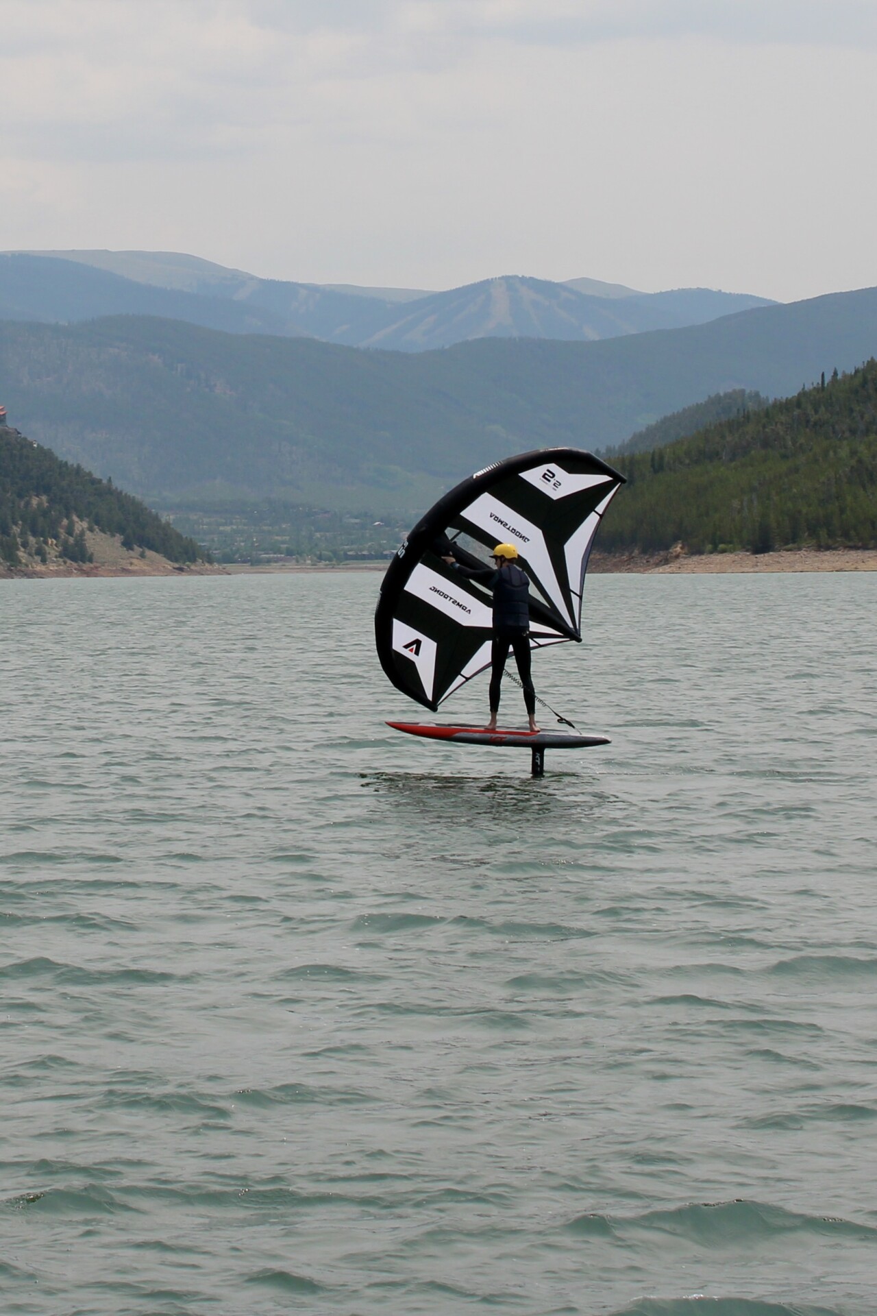 Wingfoiling rider supported by Foil Colorado coach boat
