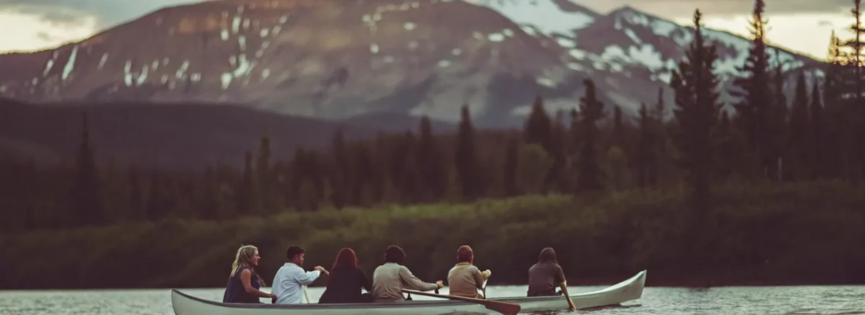 Outrigger canoe on Lake Dillon at sunset with snow-capped Rocky Mountains in background