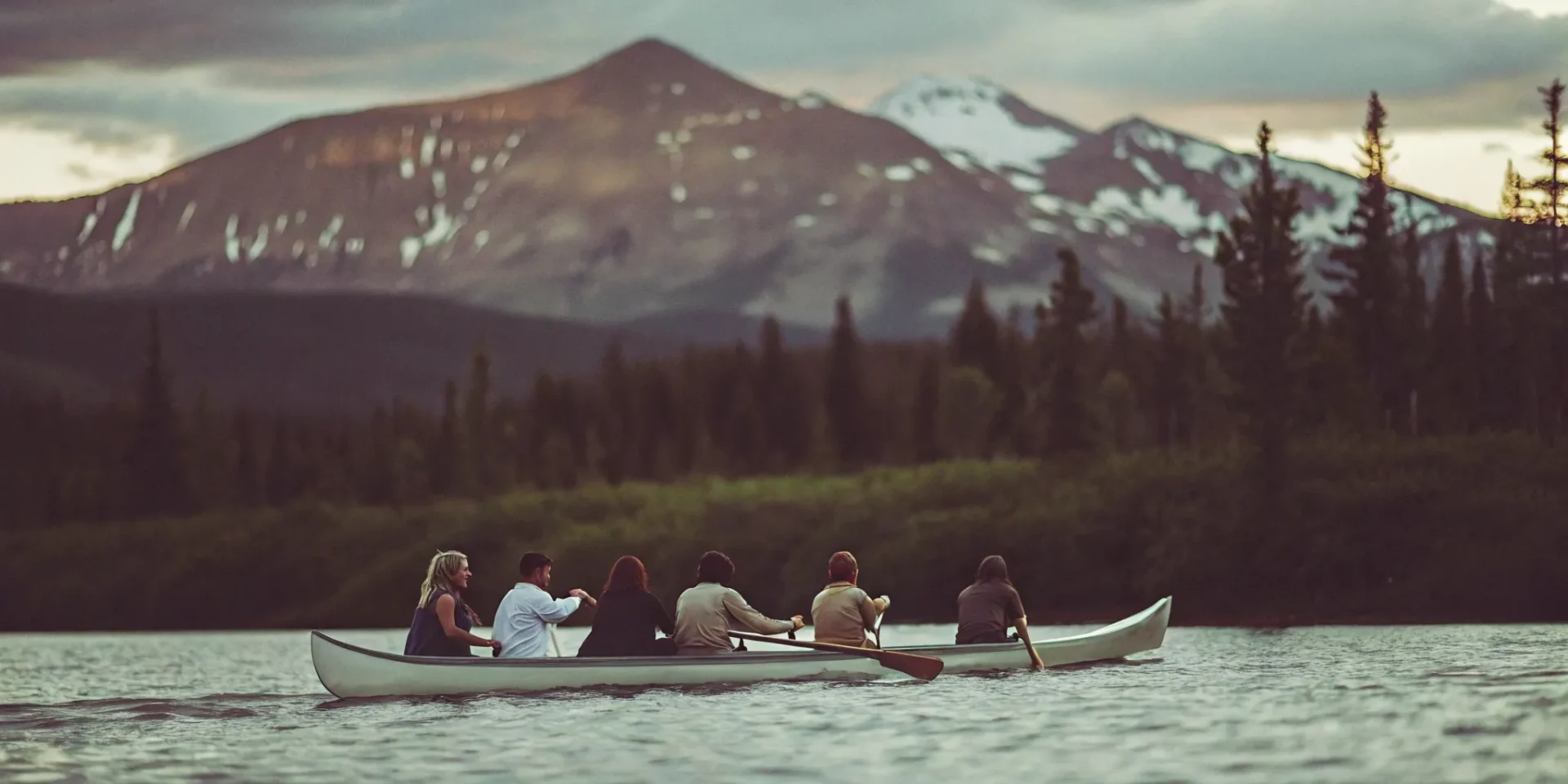 Outrigger canoe on Lake Dillon at sunset with snow-capped Rocky Mountains in background