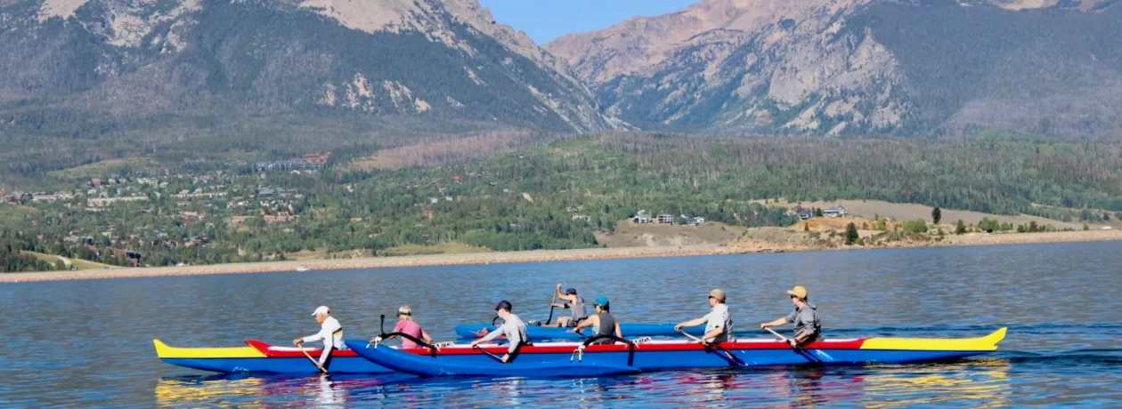 Outrigger canoe paddling on Lake Dillon with mountain views at Stand Up Paddle Colorado