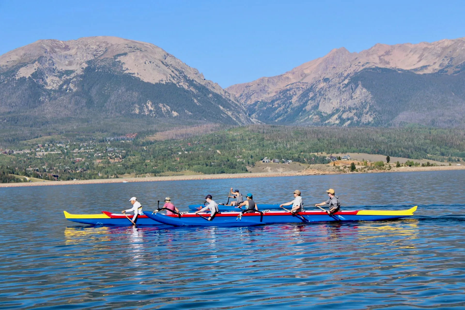 Outrigger canoe paddling on Lake Dillon with mountain views at Stand Up Paddle Colorado