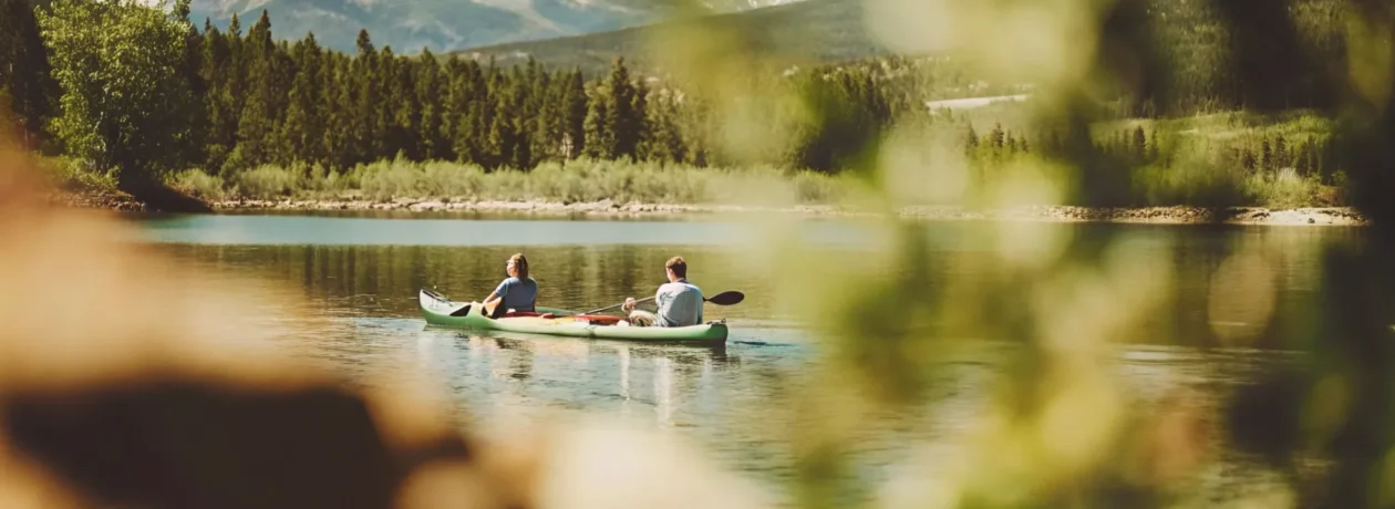 Couple paddling a tandem kayak on Lake Dillon with mountain views