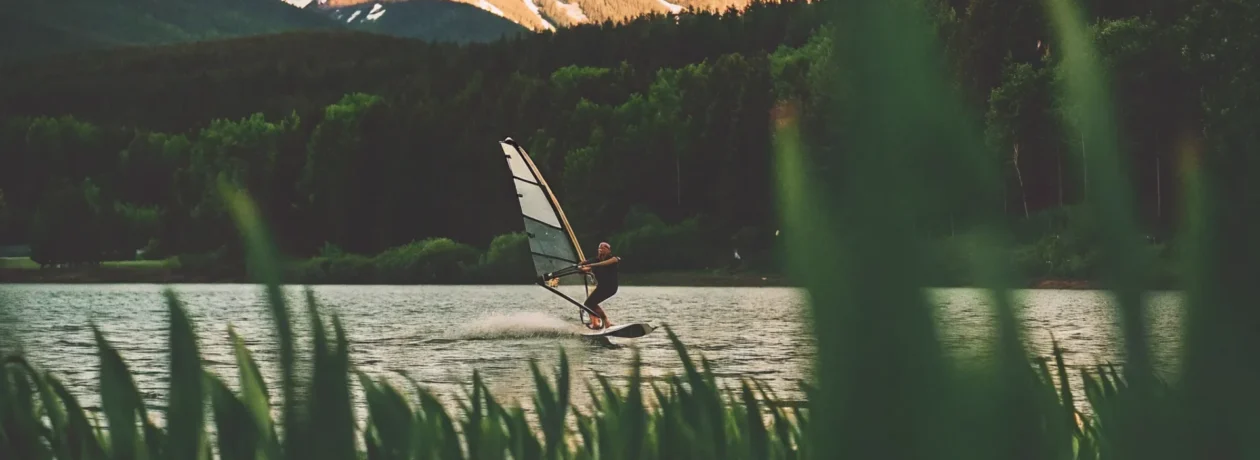 Person wingfoiling on Lake Dillon with snow-capped Colorado mountains in the background