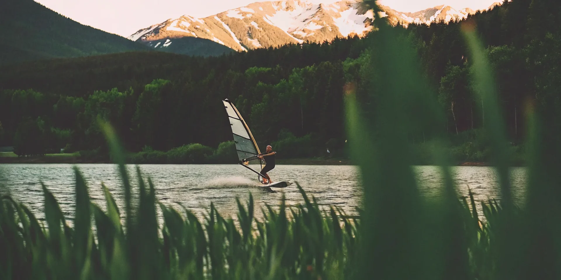 Person wingfoiling on Lake Dillon with snow-capped Colorado mountains in the background
